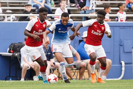 Bryan Reynolds (center in blue jersey) bursts between two Arsenal FC players during a 2018...