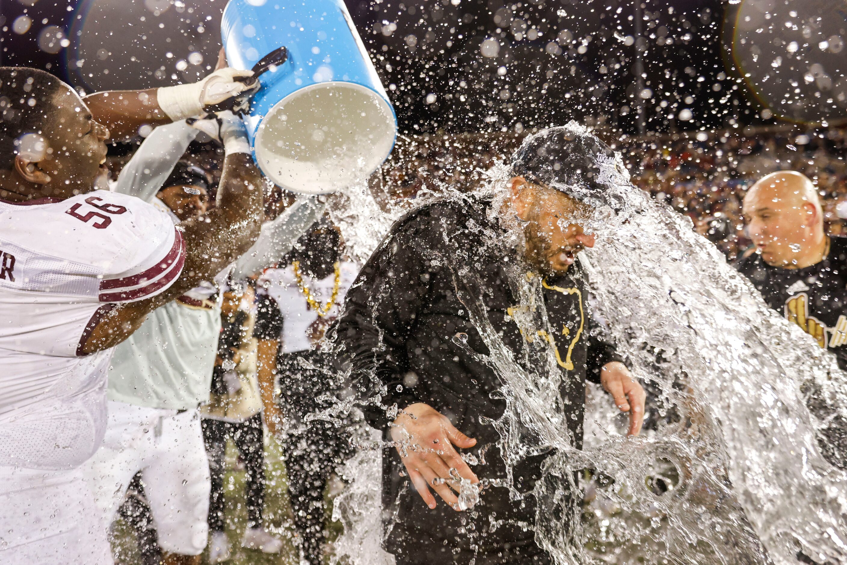 Texas State head coach GJ Kinne is doused by water ahead of his team’s victory in the First...