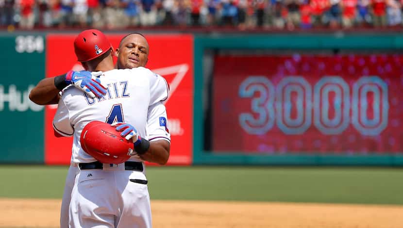 Texas Rangers Adrian Beltre receives a congratulatory hug from first base coach Hector Ortiz...