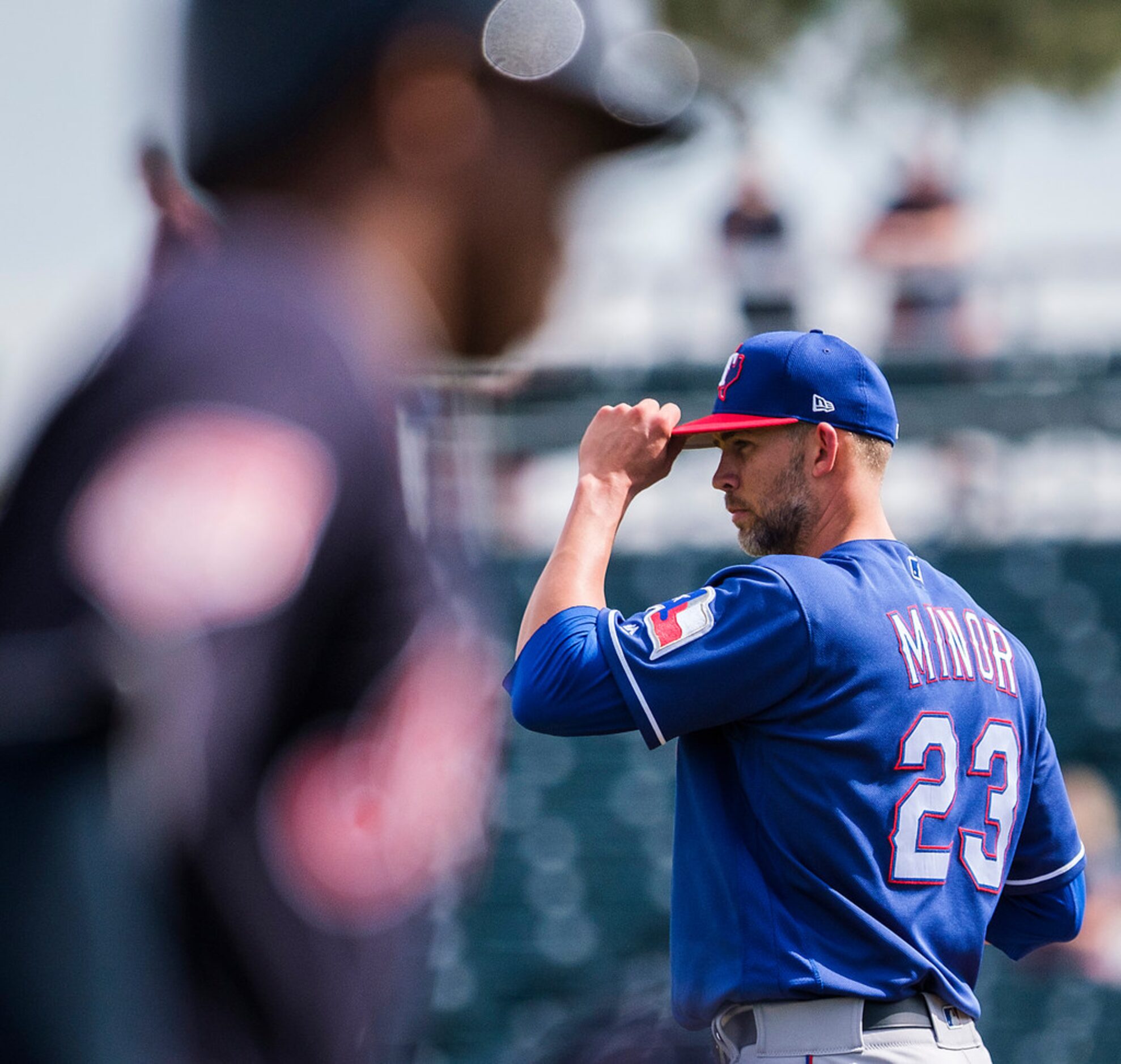 Texas Rangers pitcher Mike Minor adjusts his cap as Cleveland Indians center fielder Greg...