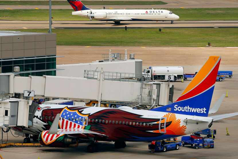  A Delta Boeing 717 jet lands at Dallas Love Field as a Southwest Airlines is parked at a...