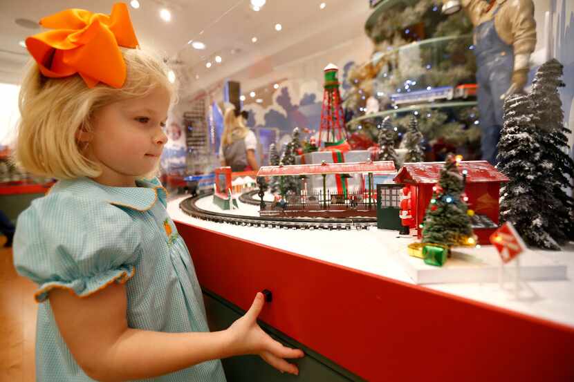 Neely Cordon, 3, looks at a miniature display at an exhibit of "The Trains at NorthPark...