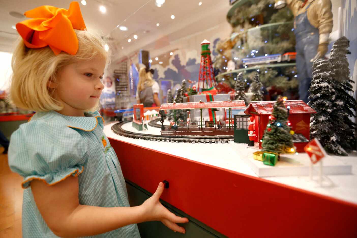 Neely Cordon, 3, looks at a miniature display at an exhibit of "The Trains at NorthPark...