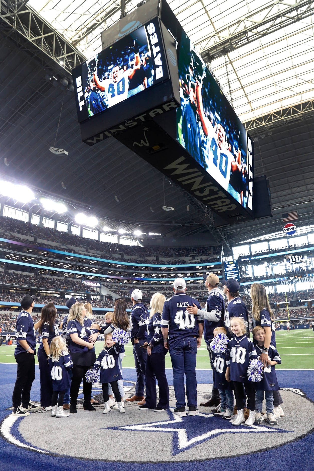 Surroudned by family, former Dallas Cowboys linebacker Bill Bates (center) looked to the...