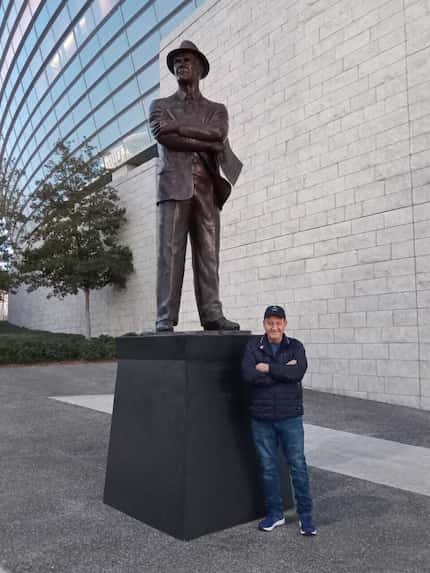 Marcos Chicurel of Mexico City fulfills a dream of posing with the statue of former Cowboys...