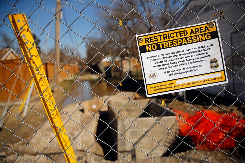 A National Transportation Safety Board sign on Friday warned people to stay out of the alley...