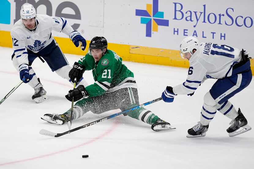 Dallas Stars left wing Jason Robertson (21) loses control of the puck under pressure from...