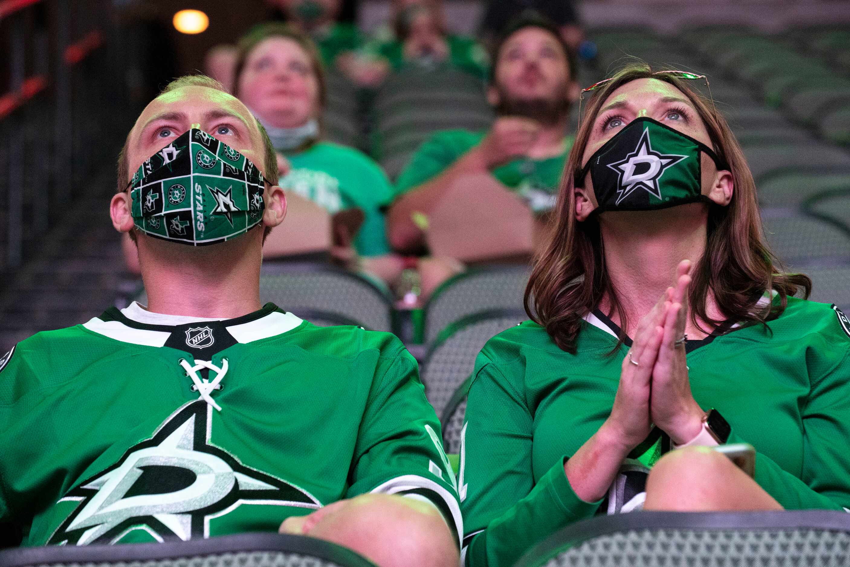 Rupert Munro, 33, and Whitney Munro, 38, of Coppell, sport Dallas Stars face coverings as...