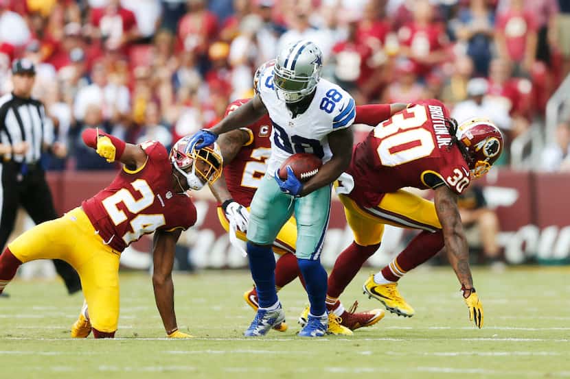 Dallas Cowboys wide receiver Dez Bryant (88) breaks a tackle from Washington Redskins...