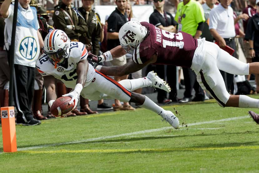 Auburn wide receiver Eli Stove (12) dives for the end zone for a touchdown as Texas A&M...