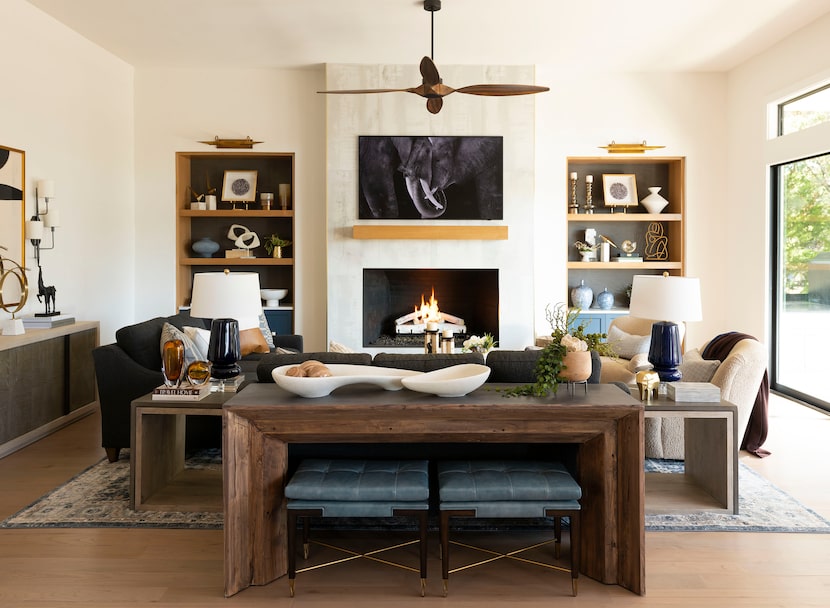 Living room with fireplace, floating mantel, sofas and chairs, and reclaimed wood table