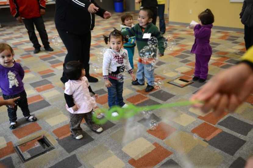 Toddlers chase bubbles during Juega Conmigo. Now in its third year, the program gives the...