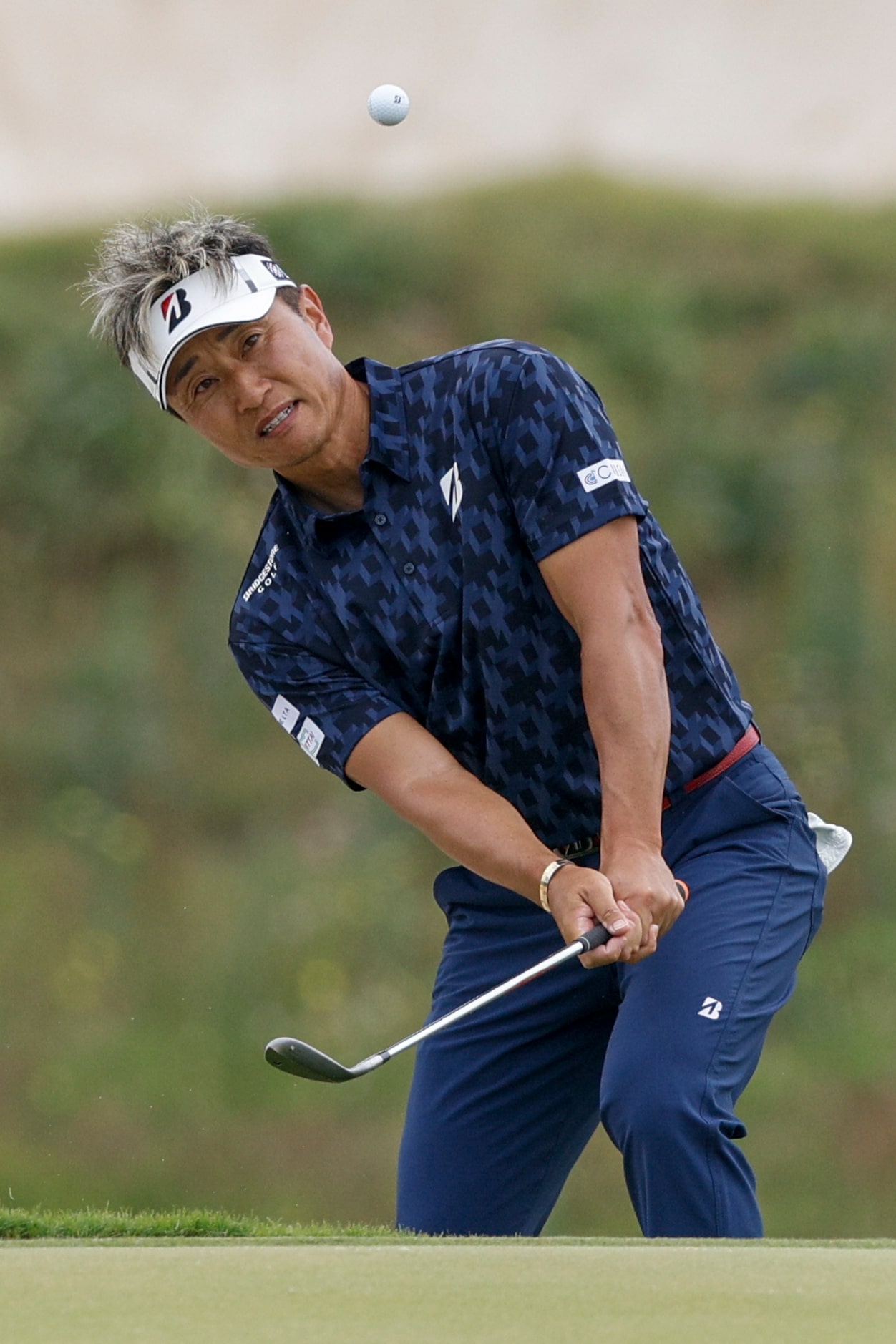 Katsumasa Miyamoto of Japan chips onto the eighth green during the first round of the...