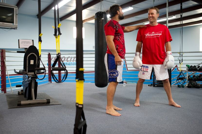 NASCAR driver Kevin Harvick (left) gets some advice during his training session with MMA...