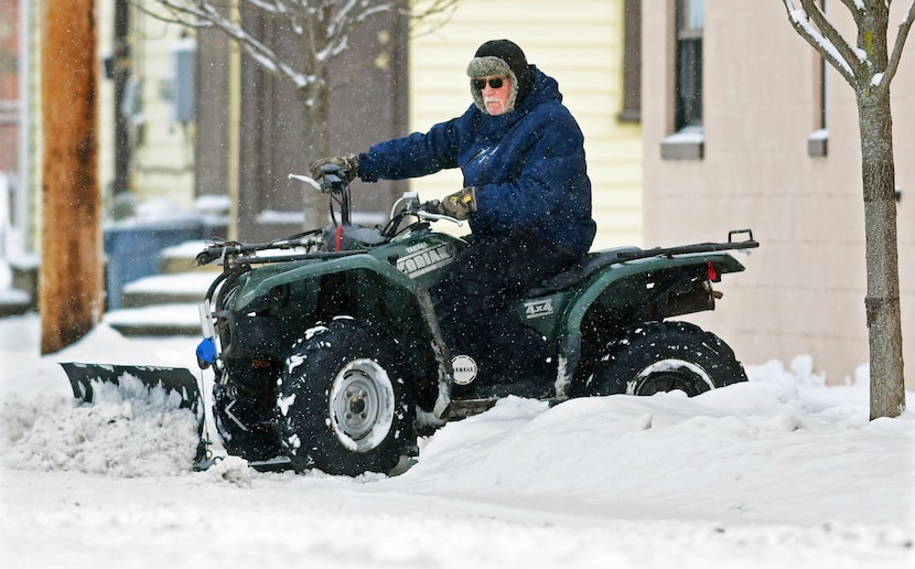 John Lovrich uses his Yamaha Kodiak 450 4x4 all-terrain vehicle to plow snow near his home...