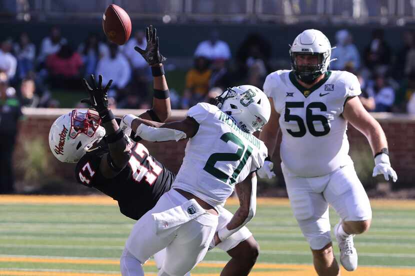 Houston linebacker Latreveon McCutchin, left, and Baylor running back Dominic Richardson...