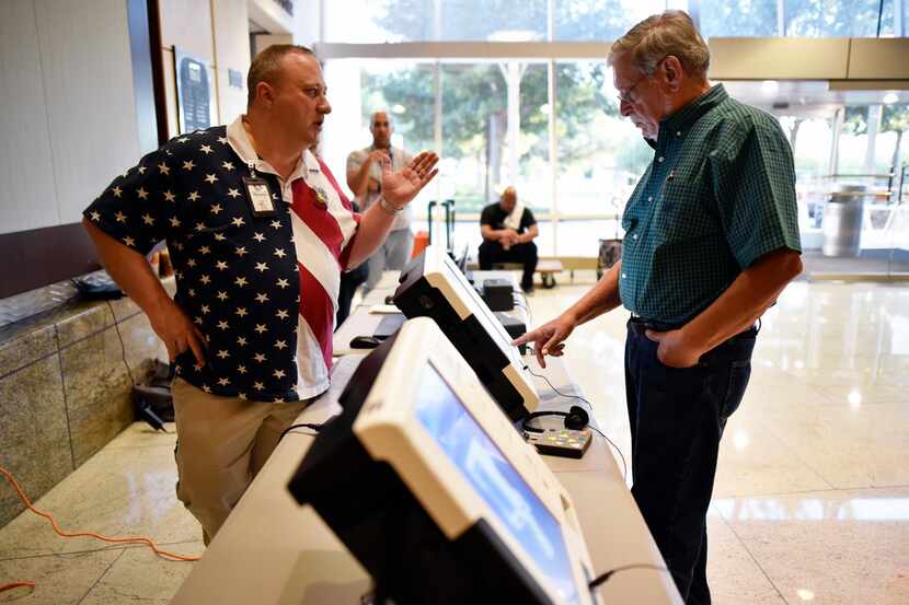 Daniel Bradley, left, Central Count manager for Dallas County Elections, guides Ron Abraham,...