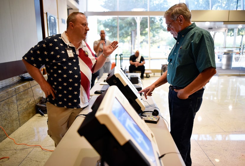 Daniel Bradley, left, Central Count manager for Dallas County Elections, guides Ron Abraham,...