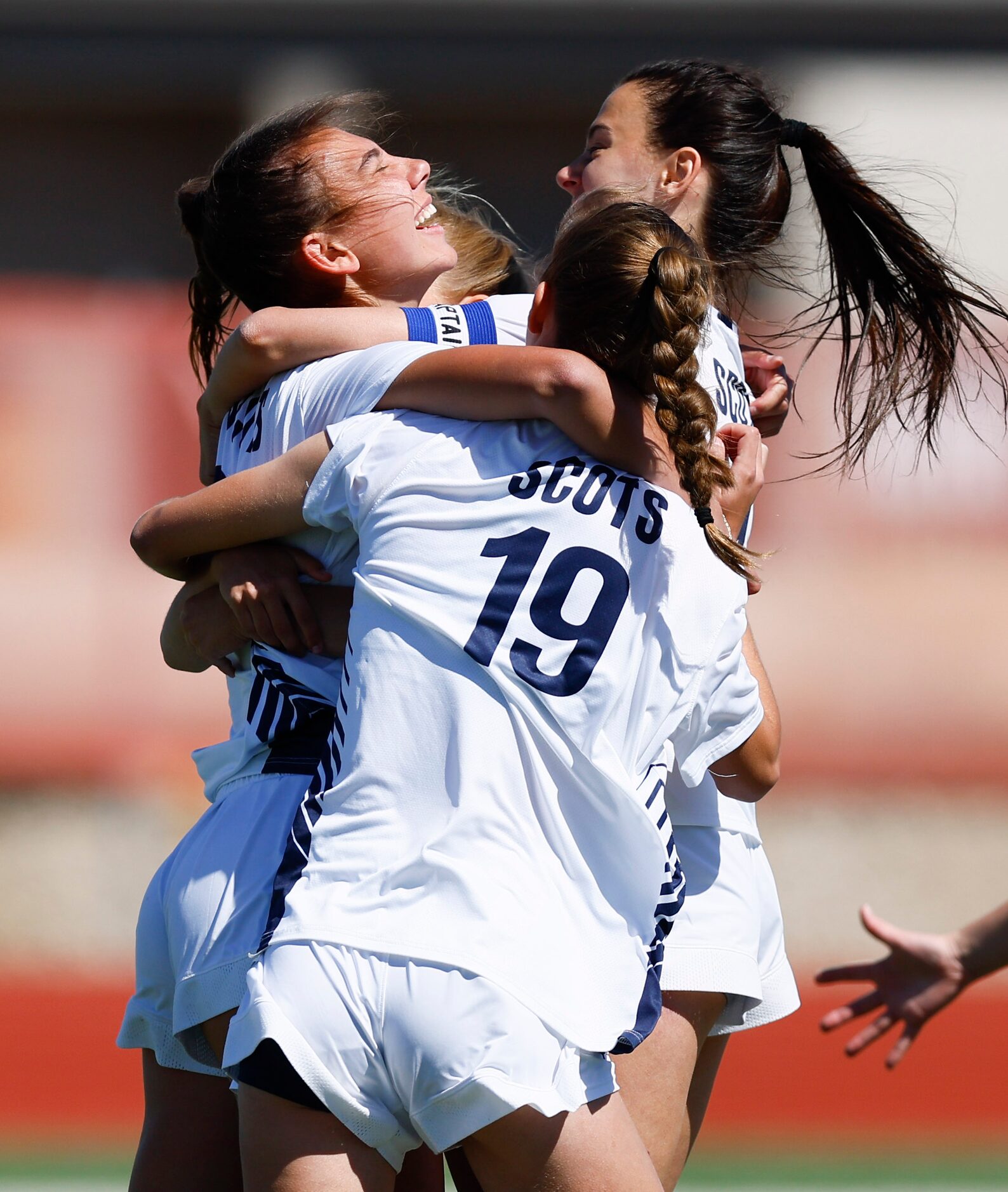 Highland Park’s Parker Buckroyd, left, is congratulated by teammates after scoring the game...