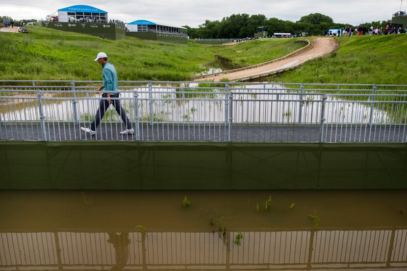 Jordan Spieth crosses a bridge over a flooded low area on his way to hole 7 during round 3...