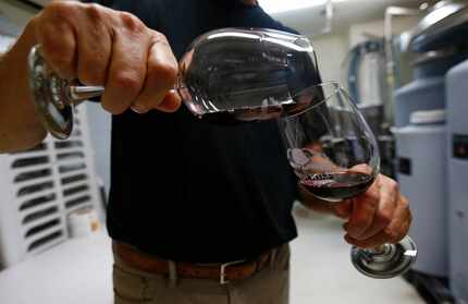 Clark Hornbaker splits a glass of wine at Eden Hill Vineyard & Winery in Celina.