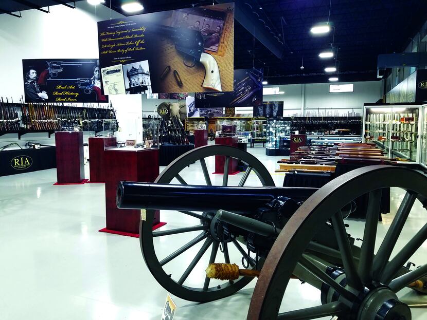 Workers from Rock Island Auction Co. auction firearms and collectibles at the company's...