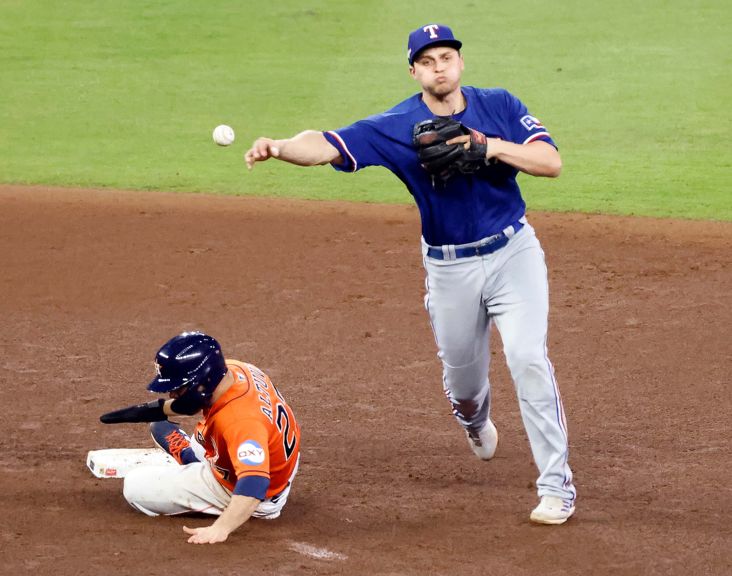 Texas Rangers shortstop Corey Seager (5) turns the front end of a double play to get Houston...