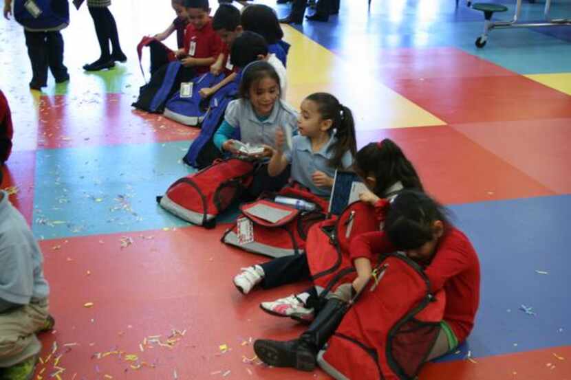 
Students at F.M. Gilbert Elementary go through the free backpacks they had been given on...