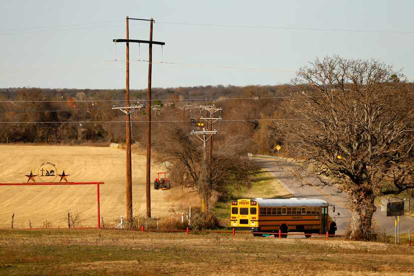 A school bus passes by a ranch entrance outside of Reno in rural Parker Co., Tuesday,...