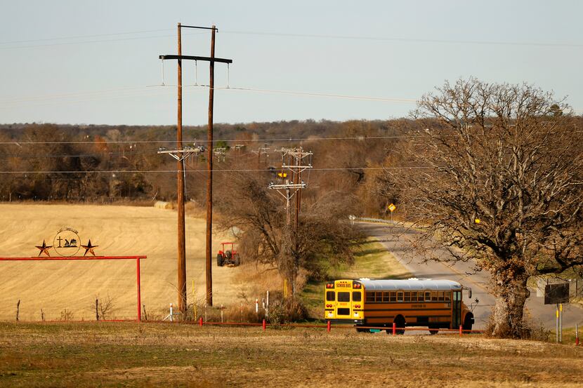 A school bus passes by a ranch entrance outside of Reno in rural Parker County on Dec. 16,...