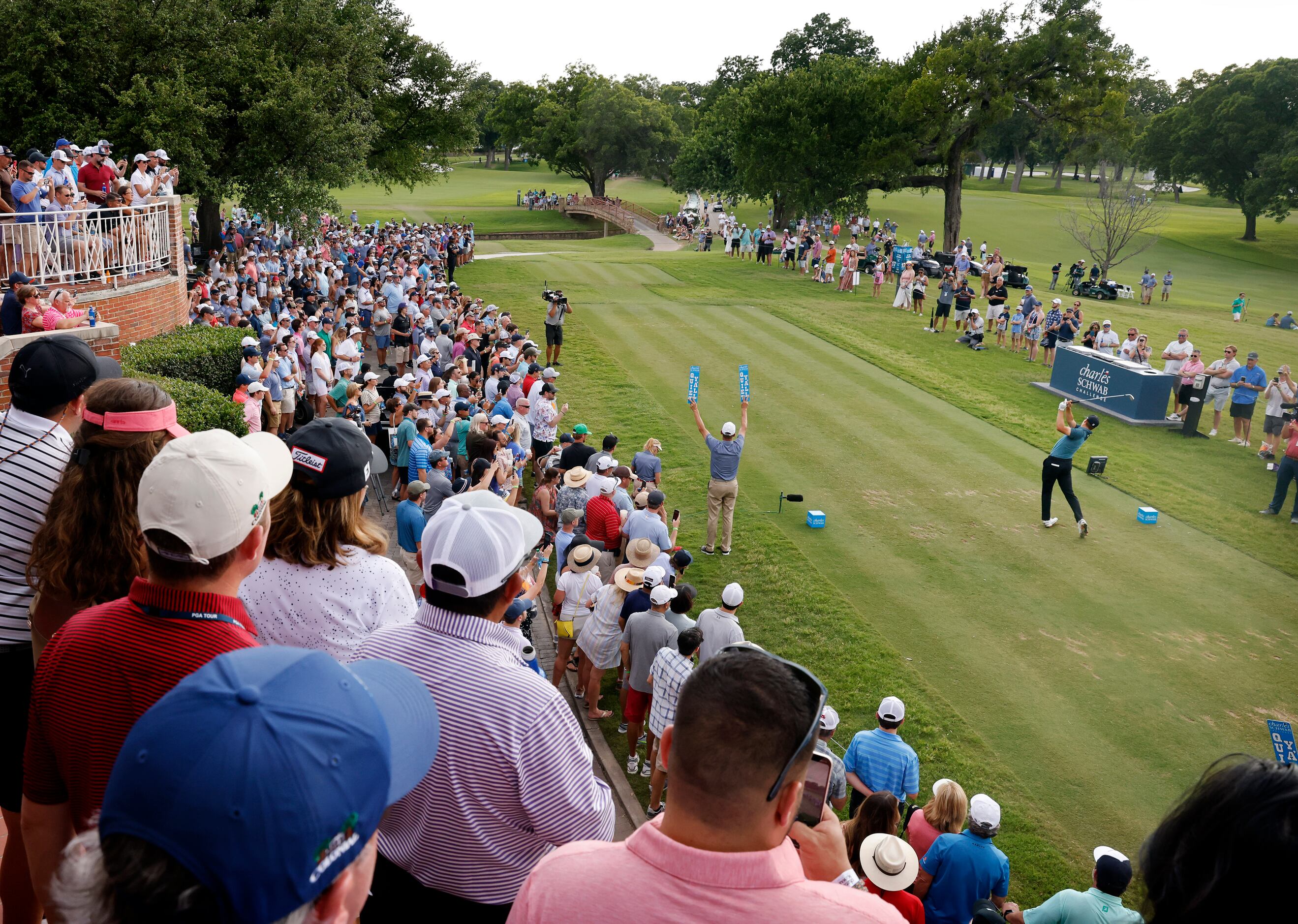 With a gallery of onlookers, professional golfer Jordan Spieth tees off on No. 17 during his...