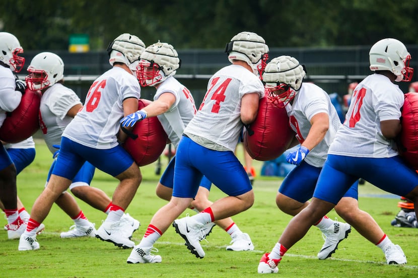 Football players work out during SMU's first football practice of the season on Tuesday,...