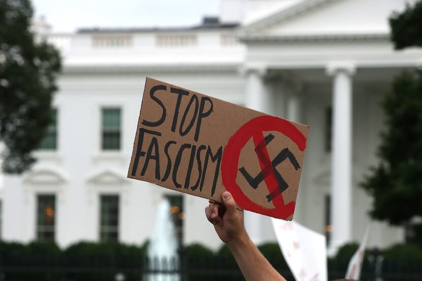  A man holds up a sign during a protest against racism gathered in front of the White House,...