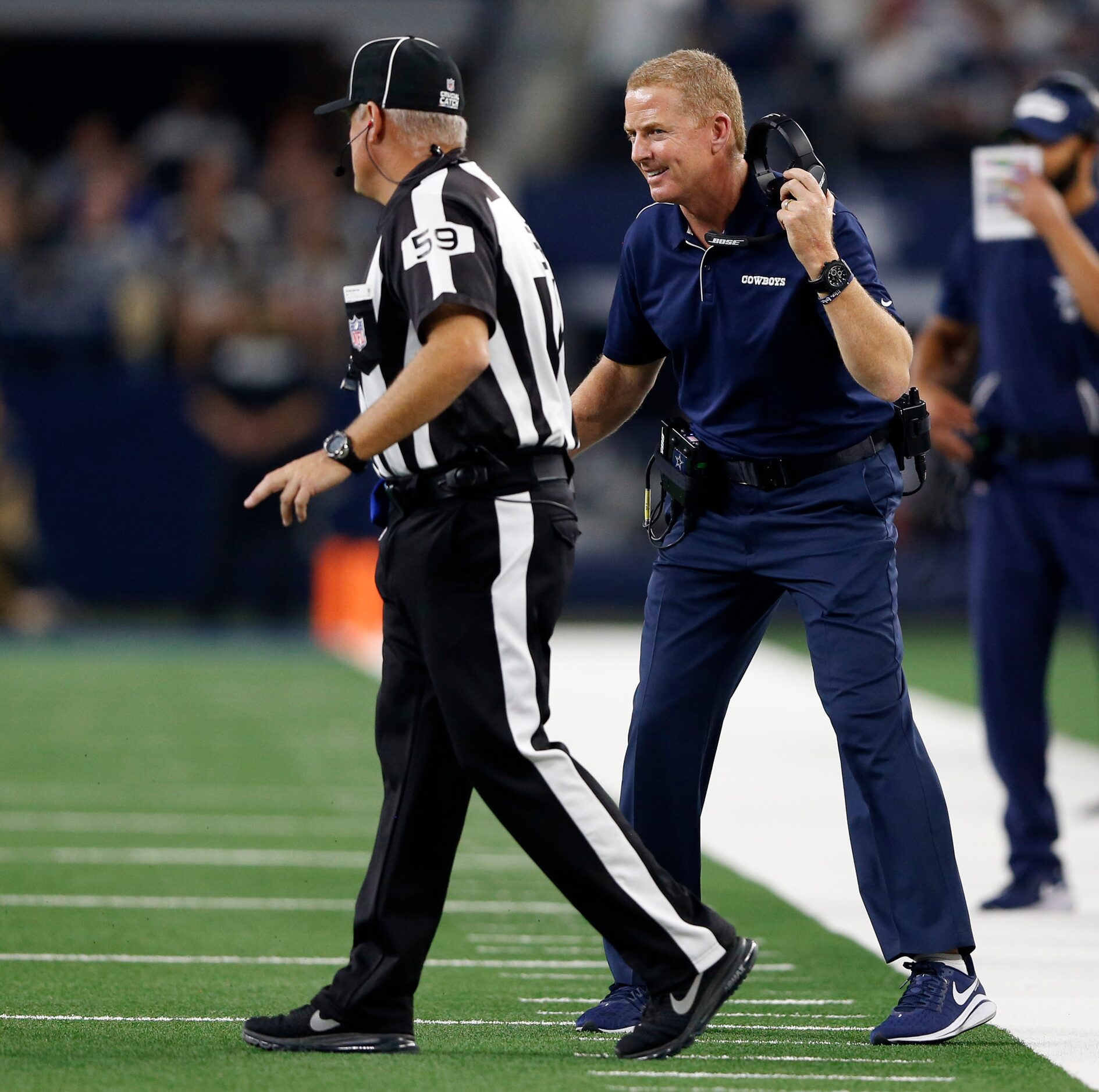 Dallas Cowboys head coach Jason Garrett talks with line judge Rusty Baynes (59) in a game...