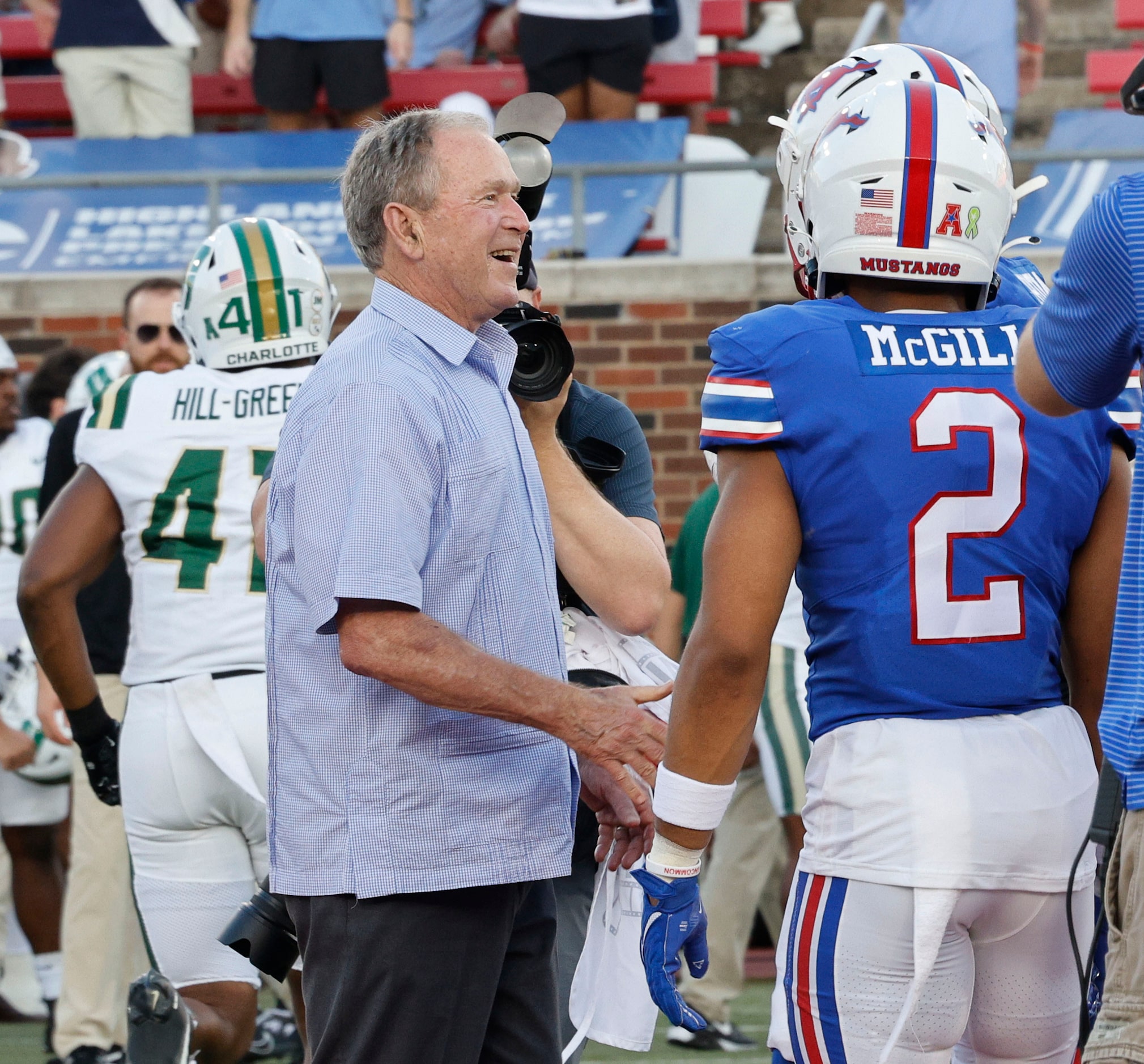 Former President George W. Bush, left, talks with SMU players including SMU safety Jonathan...