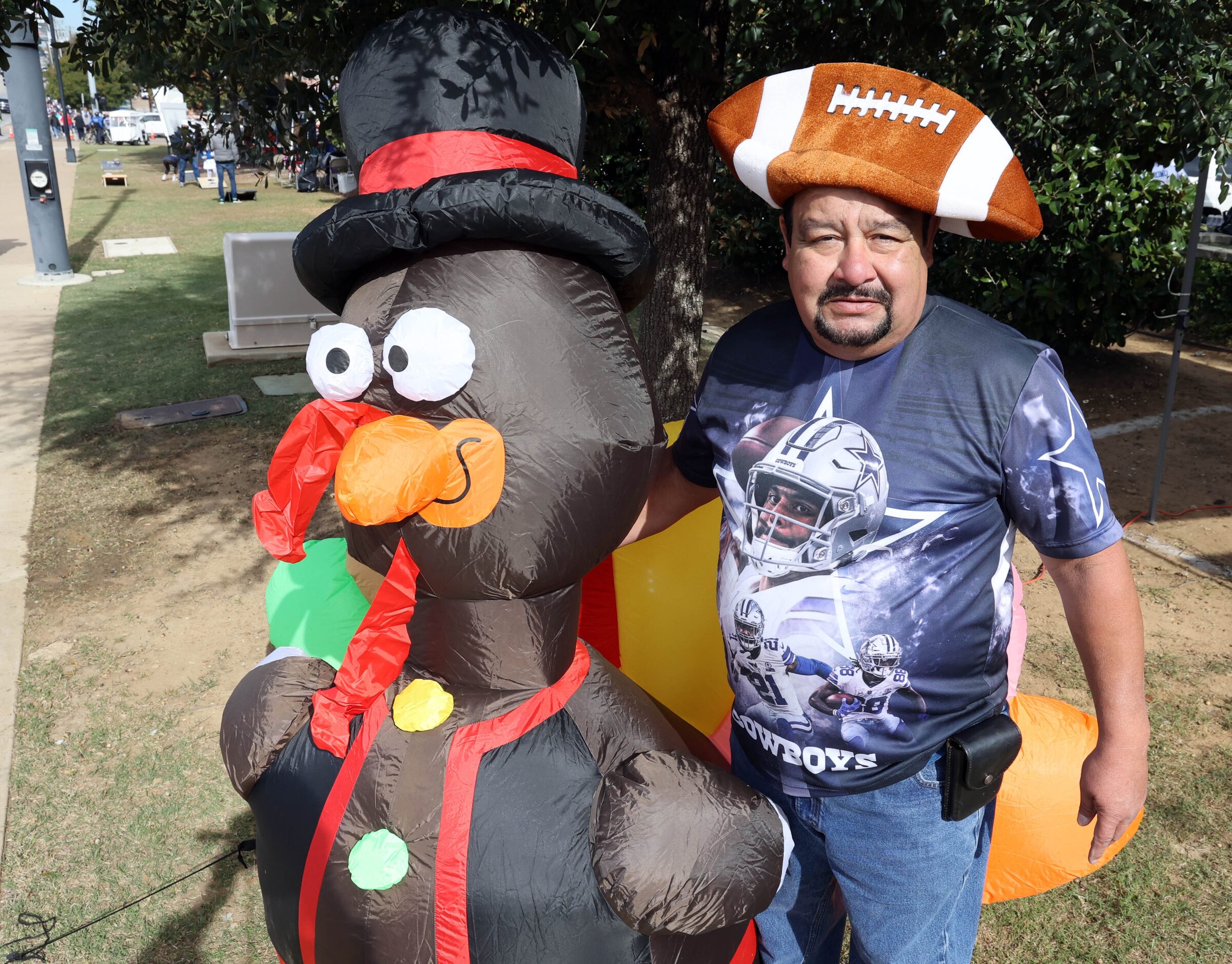 Mike Vasquez, of El Paso, TX, clad in a deflated football hat, poses with a turkey while...