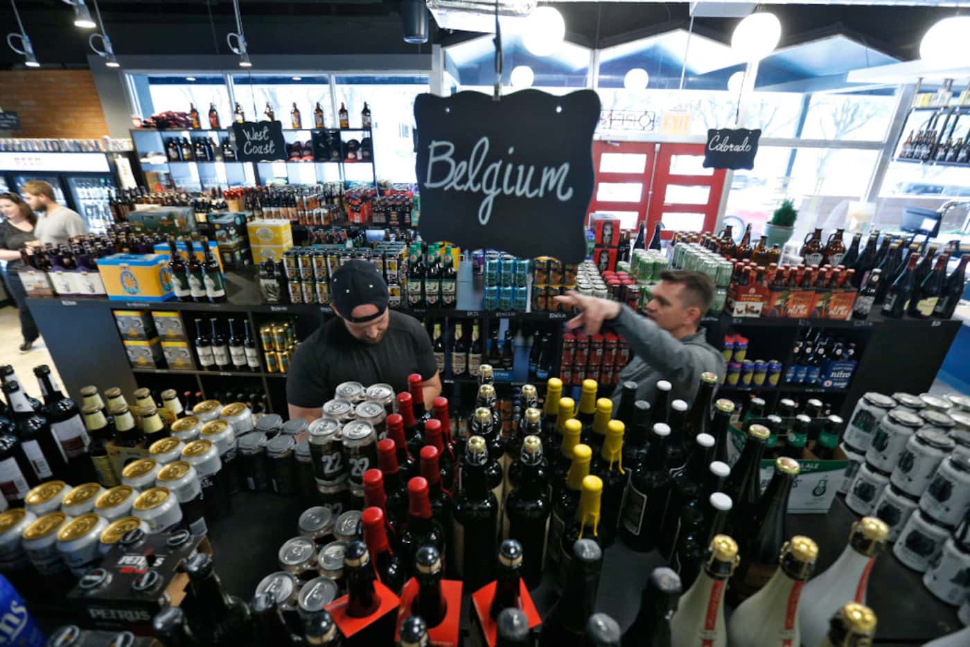 John Passiales (left) and Wes Cousino look through the beers at Craft Beer Cellar, which is...