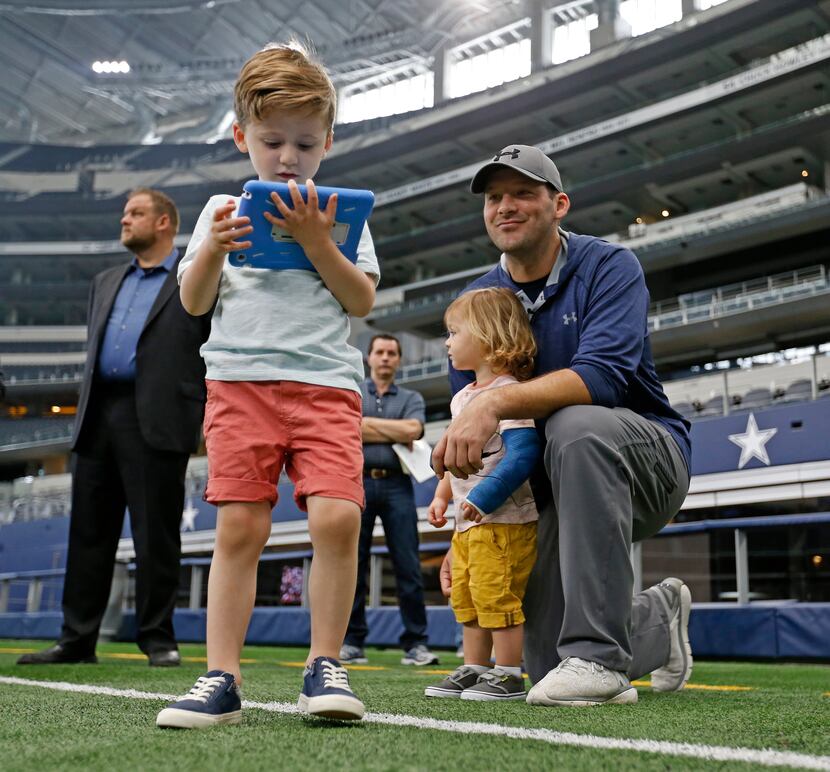 Cowboys quarterback Tony Romo - with sons Hawkins (left) and Rivers - speaks during the All...