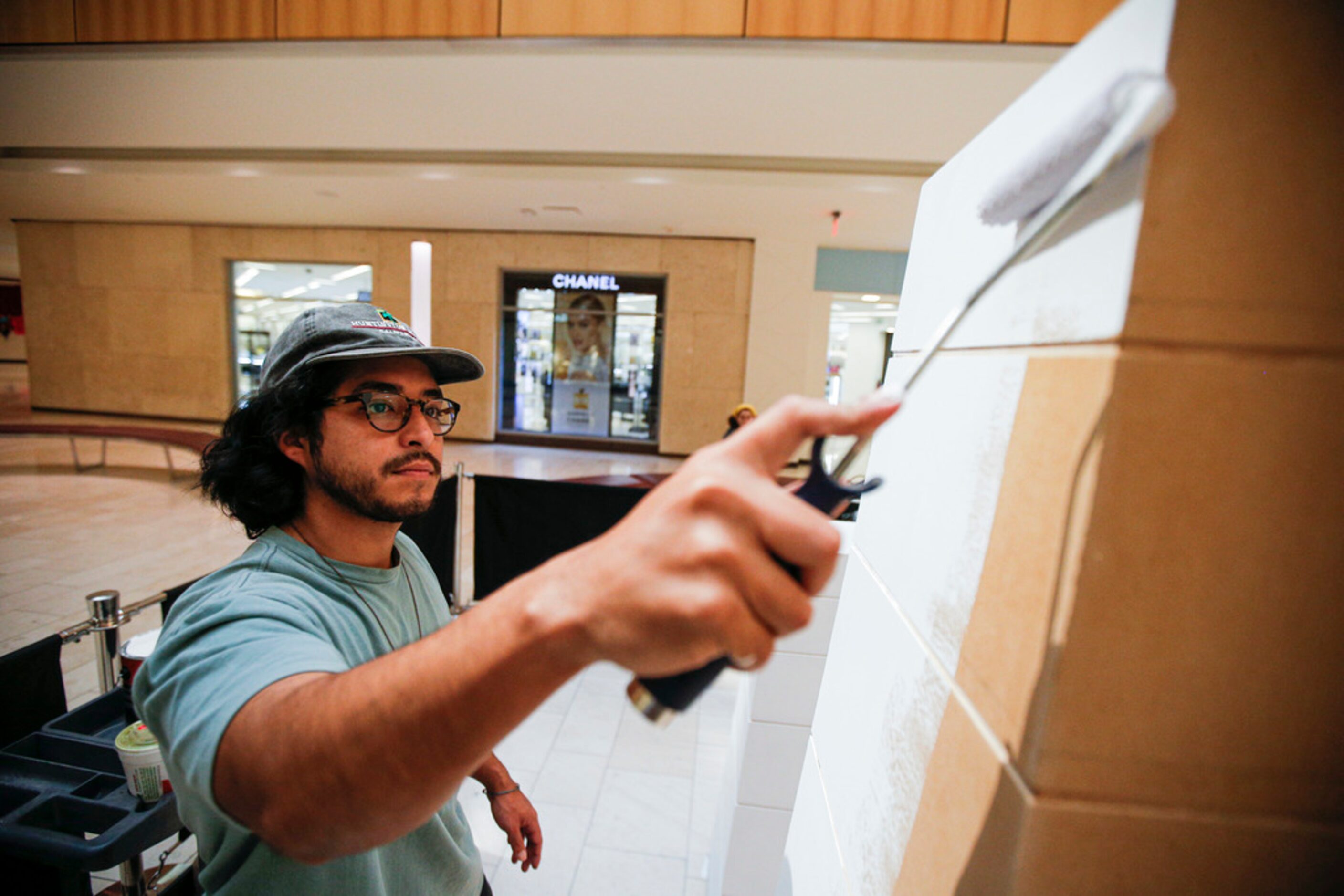 Artist Drigo, Eric Rodriguez, uses primer as a base for his piece 'Growing Up' at Galleria...