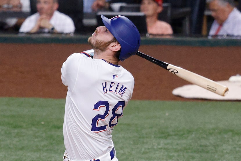 Texas Rangers catcher Jonah Heim hit a fly during the fourth inning of a baseball game...