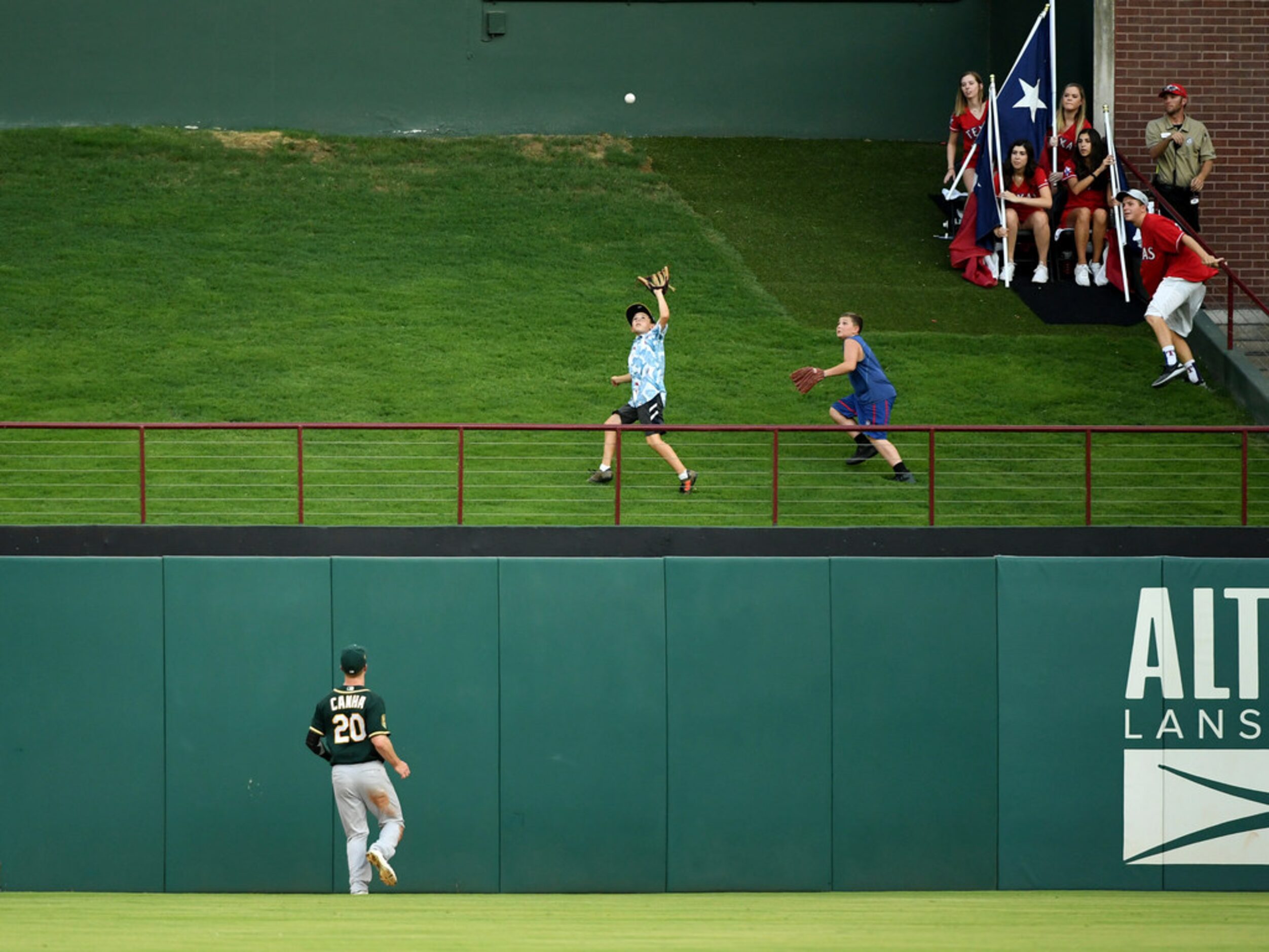 Oakland Athletics center fielder Mark Canha (20) looks up as fans run onto the grass beyond...