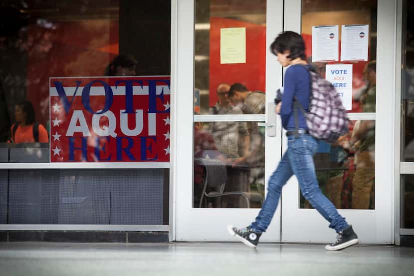 
Voter ID requirements hang on doors outside a polling place on the University of Texas...