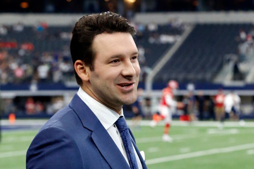CBS football analyst Tony Romo walks across the field during warm ups before an NFL football...