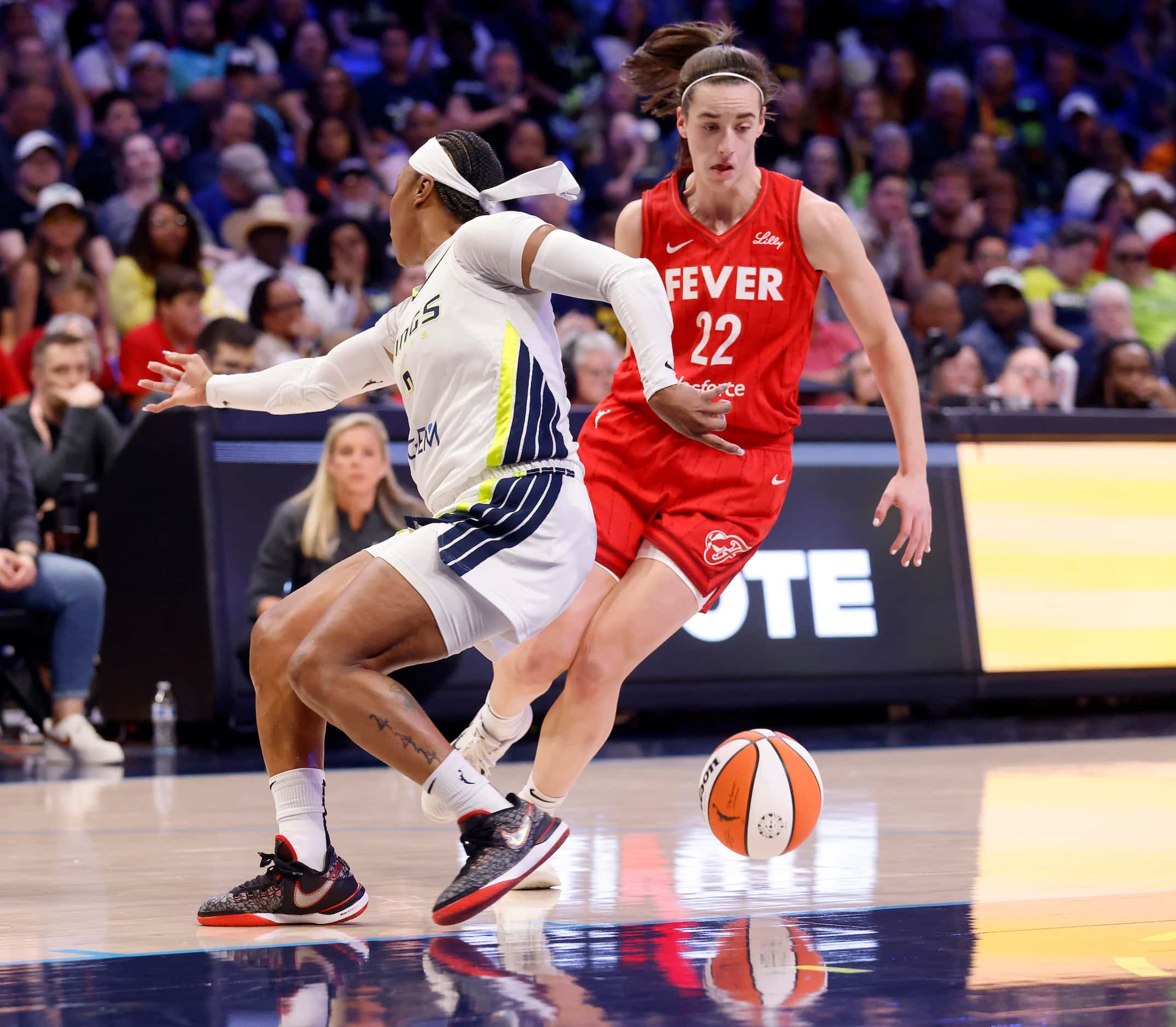 Indiana Fever guard Caitlin Clark (22) makes a pass behind the back she races downcourt...