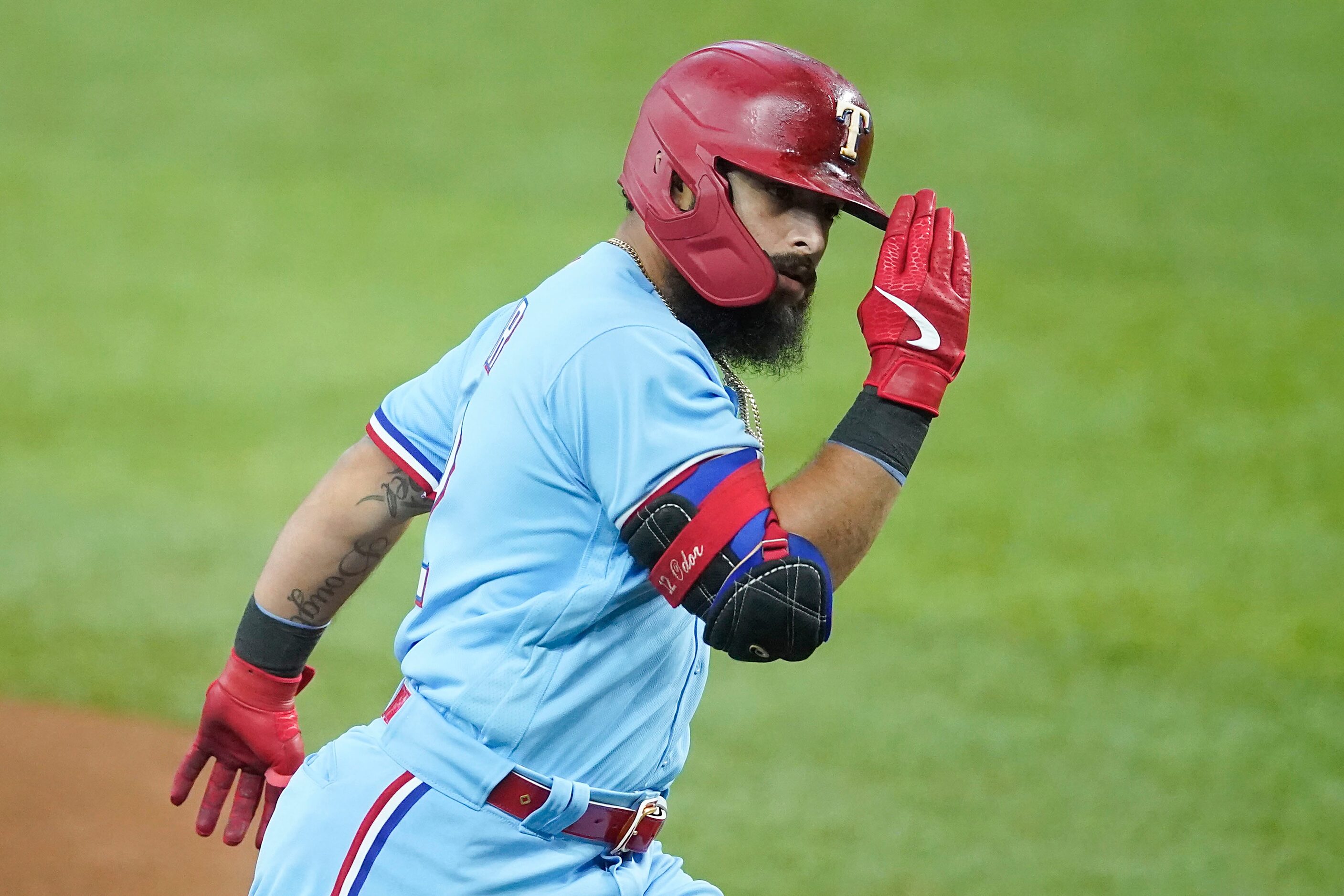 Texas Rangers second baseman Rougned Odor salutes third base coach Tony Beasley as he rounds...