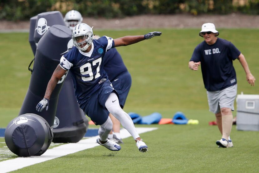 Dallas Cowboys Taco Charlton (97) knocks down dummies in a drill as Dallas Cowboys defensive...