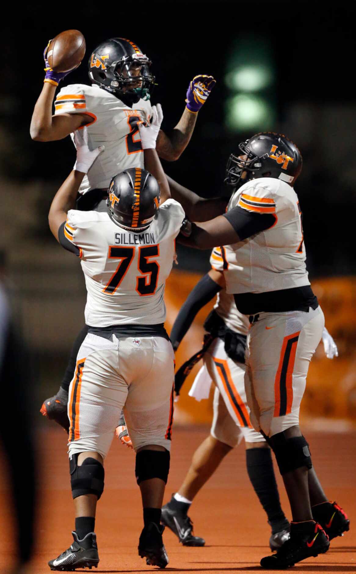 Lancaster running back Tre Bradford (2) is hoisted into the air by lineman Isaiah Sillemon...