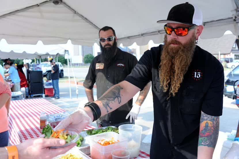 Then-Lockhart pitmaster Will Fleischman serves up a smoked dandelion green salad at the Pit...