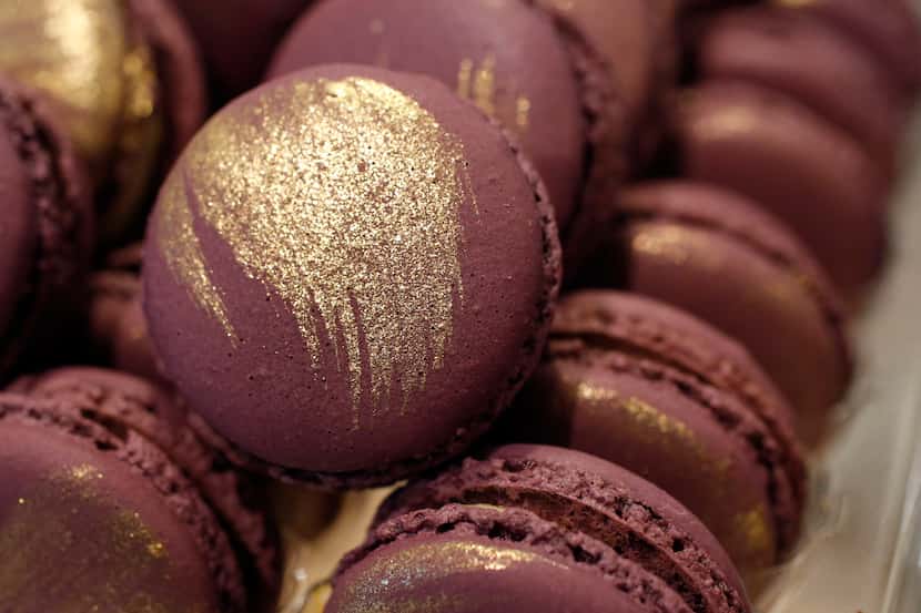 Honey lavender macarons stand out in the case because of their bright color and gold glitter...
