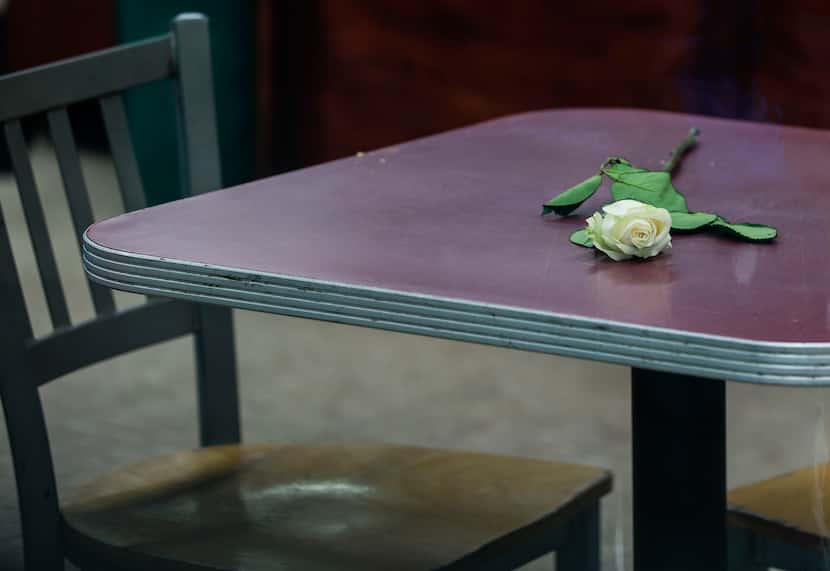 A white rose lays on a table inside the Texaco gas station after the vigil in Garland,...